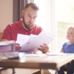 Man reviewing documents at dining table.